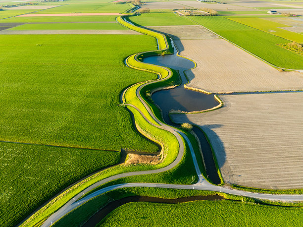 弯道的鸟瞰图。穿过田野的路。图片壁纸，背景，设计。乘汽车或摩托车旅行。全景。无人机拍摄的风景。图片下载