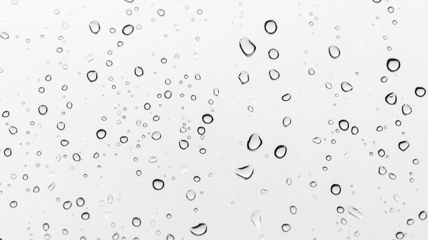 雨滴在透明玻璃上形成优雅的水珠，微距照片图片下载