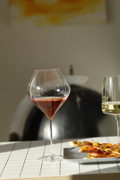 桌子上的一杯白葡萄酒、一杯玫瑰葡萄酒和番茄派图片下载