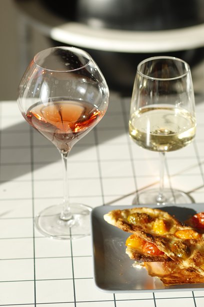 桌子上有一杯白葡萄酒、一杯玫瑰葡萄酒和一个番茄派图片下载