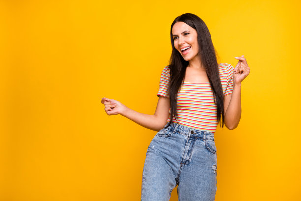 在鲜艳的紫色背景下，跳舞的女人享受派对，唱着歌，面朝空旷的空间的照片肖像。图片下载