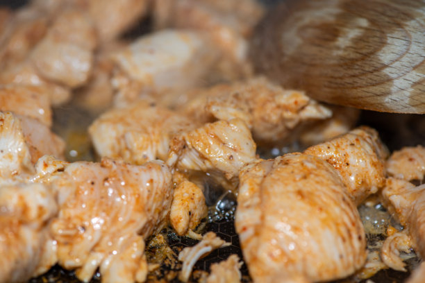 女人在烹饪鸡肉炒菜的特写照片图片下载