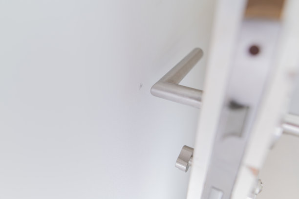 检查新单元房门的检查员未安装门挡，导致墙壁受损的库存照片图片下载