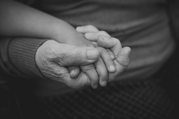 特写镜头中，老年人与儿童的手紧紧相握，表达出温暖、关爱和代际纽带，体现家庭和连接的概念，黑白照片中的祖母与孙女。图片下载