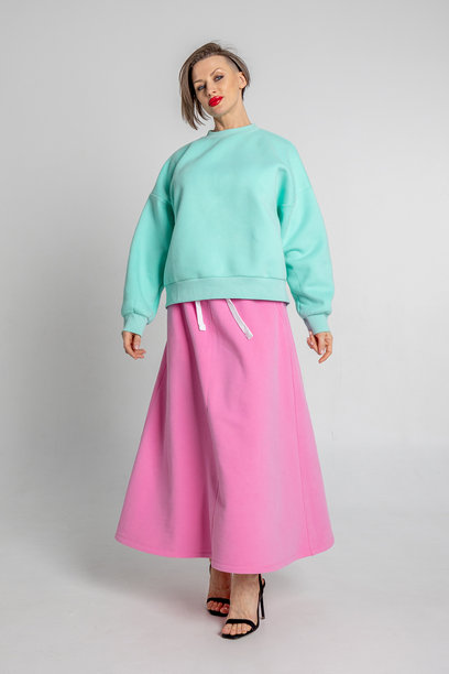 美丽的模特外貌女孩。穿着薄荷色卫衣和粉色裙子的美丽女性肖像。竖版照片图片下载