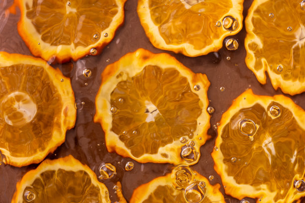 水面上的气泡照片，背景是一个切开的橙子。图片下载