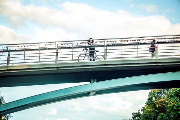 骑自行车的女人在拍摄渥太华运河的照片图片下载