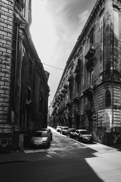 黑白照片，狭窄街道两侧停满了汽车图片下载