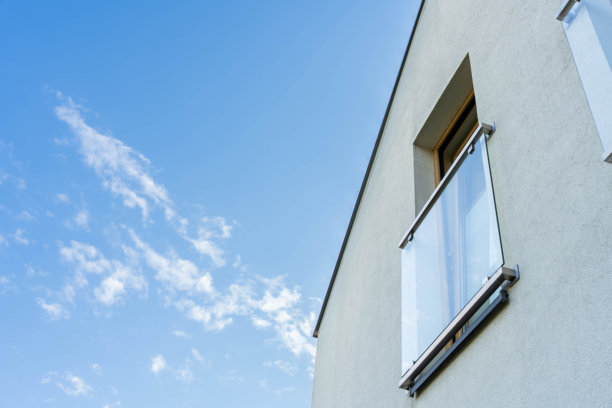 现代住宅的极简主义照片，带有玻璃栏杆阳台，蓝天背景，干净的建筑风格，体现当代住宅设计理念。大面积留白。图片下载