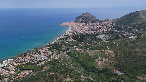 捕捉意大利切法卢迷人的海滨小镇，这张航拍照片突显了其迷人的自然风光和历史建筑。图片下载