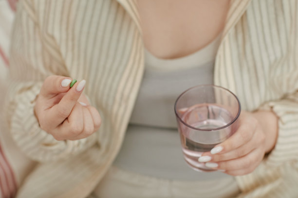 孕妇亚洲女性在喝水的同时服用产前维生素图片下载