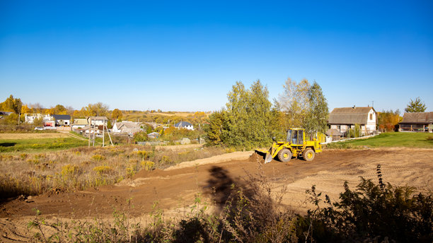 建筑工地上的黄色推土机。侧面视图的大轮挖掘机正在平整和清理土地。移动土方。留白空间。建筑区域。特种运输。高质量照片。图片下载