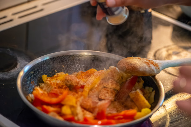 女人在烹饪鸡肉炒菜的特写照片图片下载