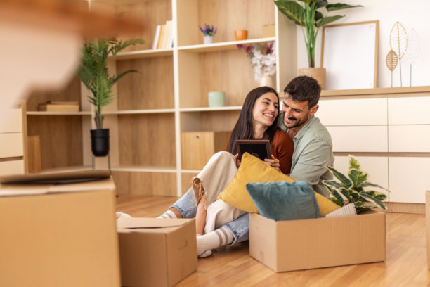 年轻夫妇在新家 unpacking 并查看照片图片下载