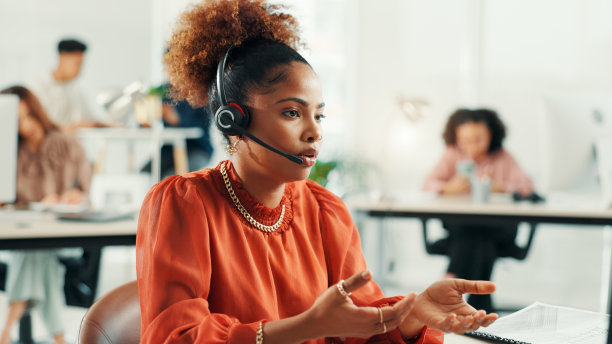 办公室内的女接待员佩戴耳机，进行在线预约设置、日程安排或支持。音频技术、咨询和女性虚拟助手进行客户关系管理集成的电话沟通。图片下载