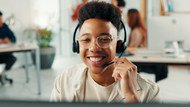 办公室里快乐的男接待员佩戴耳机，进行在线预约设置、日程安排或支持。音频技术、咨询和男性虚拟助手进行CRM集成的电话。图片下载