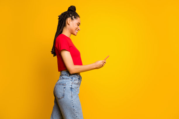漂亮的深肤色网红在黄色背景上独自聊天并撰写博客文章的个人资料照片图片下载
