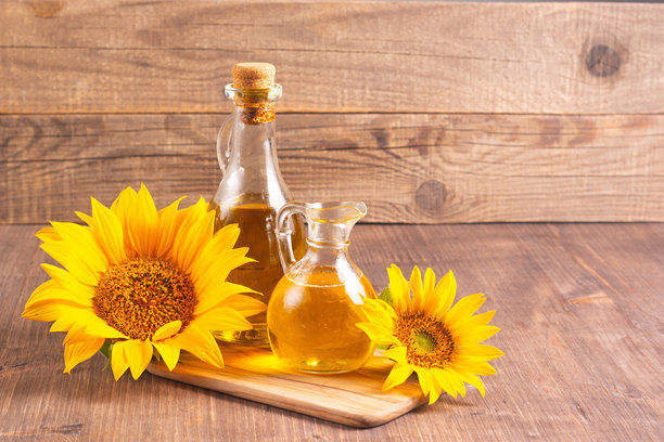 向日葵油的特写照片，背景为木质表面，旁边有种子。生物和有机产品概念。图片下载