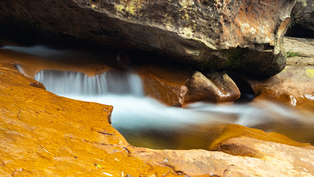 小型瀑布从岩石坡面流下。长时间曝光的白色流水照片。图片下载
