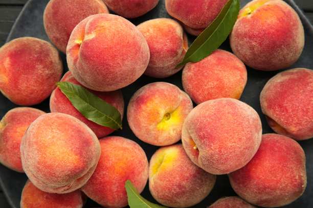 成熟的红桃与绿色叶子。微距照片图片下载