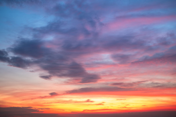 美丽的日落景观，奢华柔和的渐变橙金色云彩和阳光映照在蓝色戏剧性的天空上，完美适合作为背景，早晨、傍晚、黄昏，气候变化，横向日落照片图片下载