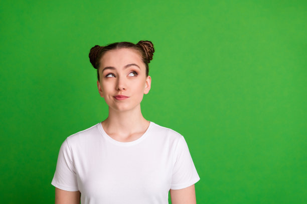 好奇模特在鲜艳绿色背景下凝视空旷空间，灵感乍现的照片肖像图片下载