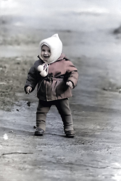 1967年的复古照片，春天里一个可爱的小男孩戴着白色帽子在街上走。图片下载