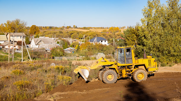 建筑工地上的黄色推土机。侧面视角的大轮挖掘机正在平整和清理土地。移动土方。留白空间。建筑区域。特种运输。高质量照片。图片下载