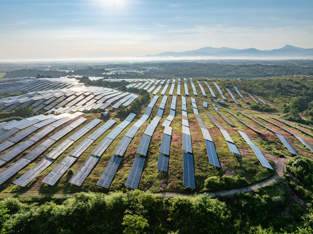 日出时分，山坡上的太阳能光伏航拍照片图片下载