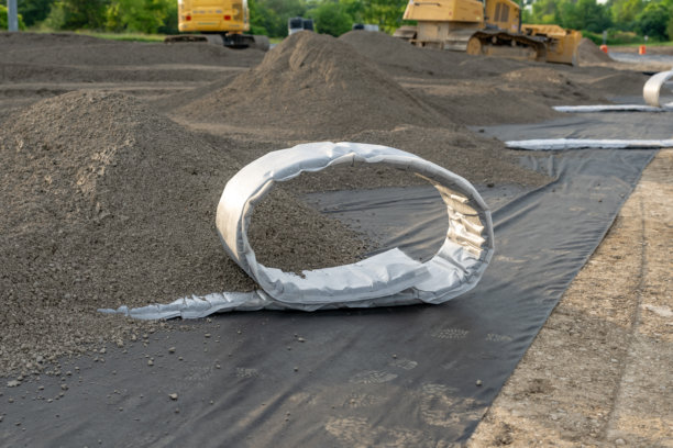 在合成草坪多功能运动场上安装平面排水管的施工照片。图片下载