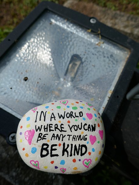 户外聚光灯灯具与“善待他人”岩石的竖版照片图片下载