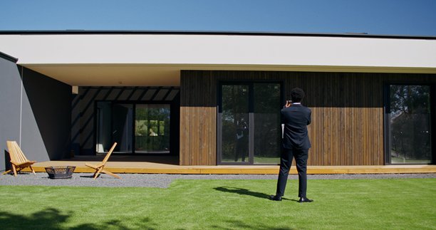 一名男子用手机拍摄房子的照片图片下载