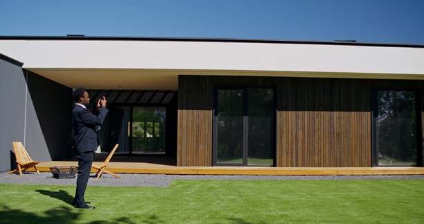 一名男子用手机拍摄房子的照片图片下载