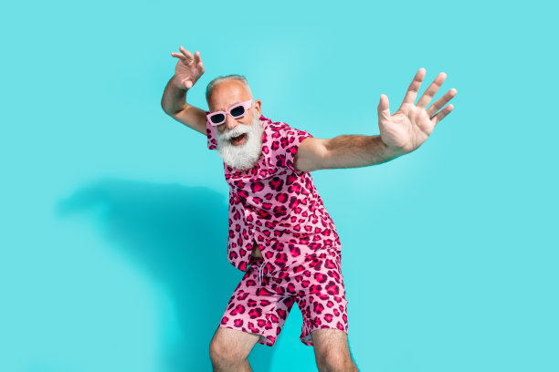 穿着豹纹服装的搞笑老年男子在青色背景下跳舞的照片图片下载