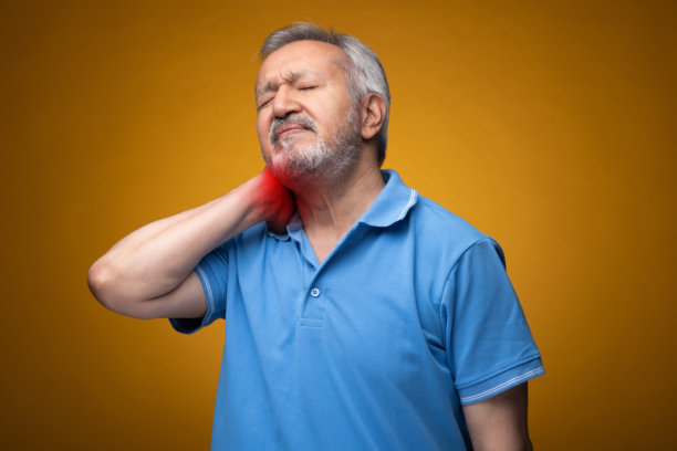 穿着蓝色T恤的老年帅气男士肖像照片，背景为黄色。图片下载