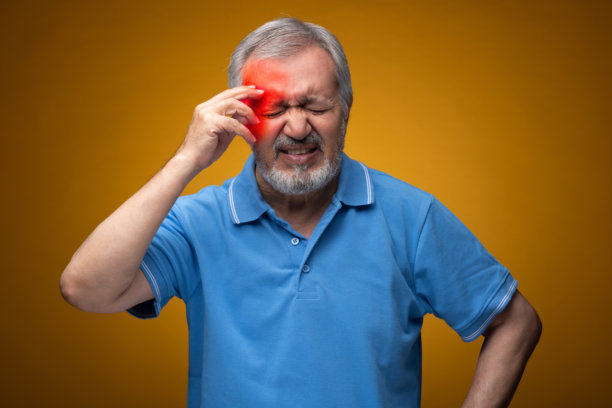 穿着蓝色T恤的老年帅气男性肖像照片，背景为黄色。图片下载