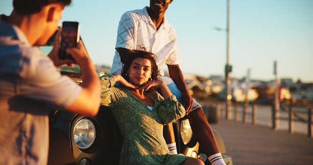 手机、摄影和朋友们在公路旅行中享受快乐假期，微笑和户外亲密相处。放松，数字照片和车内的人们使用手机，旅行冒险或假期中的快乐回忆。图片下载