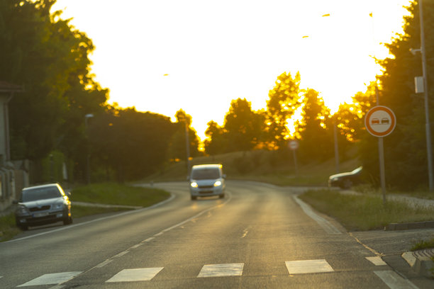 模糊的照片，多个汽车在日落时分的街道上。图片下载
