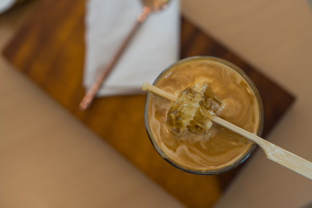 特写照片：一杯脏咖啡上面放着一块蜂蜜。图片下载