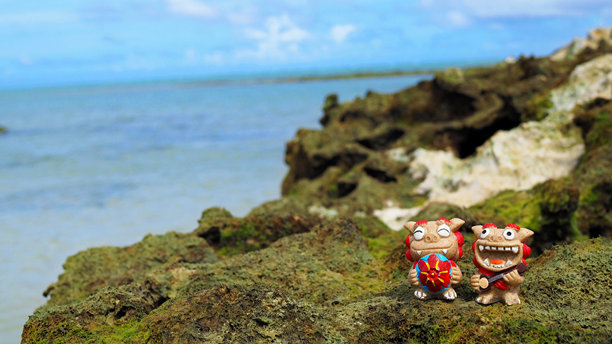 冲绳的蓝色海洋和微笑的狮子狗是冲绳的守护狮。风景照片留白。图片下载