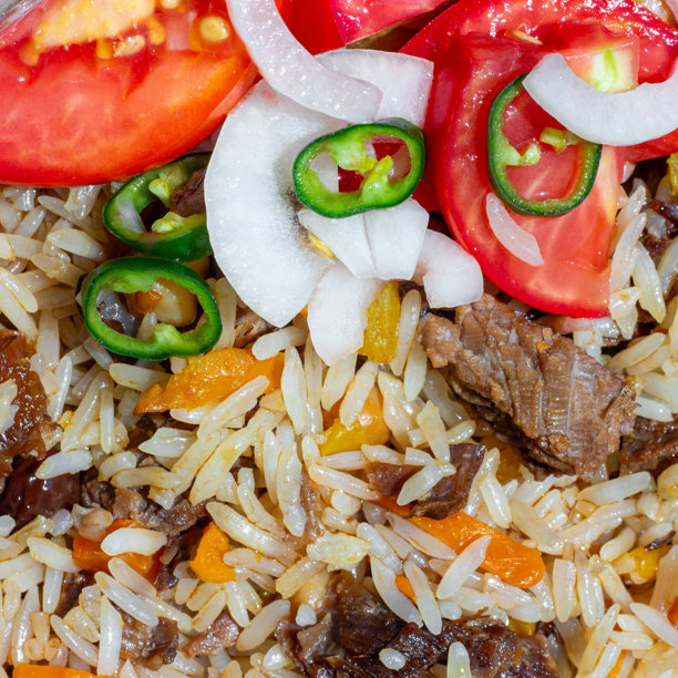 一盘米饭配肉，搭配切碎的番茄、洋葱和辣青椒沙拉。此照片适合餐饮业和任何与食品相关的设计。图片下载