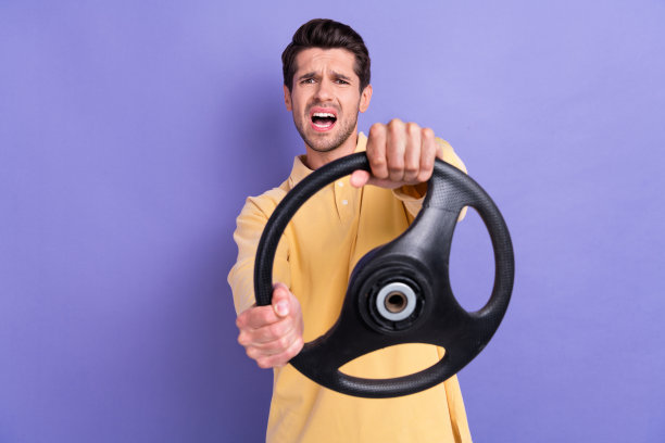 印象深刻的无言以对的人张开嘴盯着手臂抱车轮孤立的紫色背景的照片图片下载