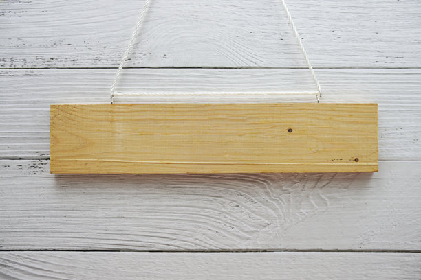 用绳子悬挂的木牌和木制背景上的人造花装饰的空白空间图片下载