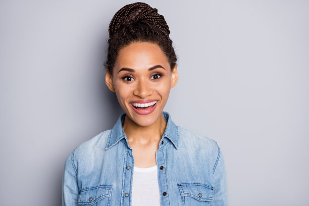 非洲裔美国女孩的照片肖像，微笑着，背景为清晰的灰色。图片下载