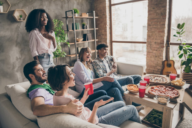 乐观的棕发和金发男士女士们穿着休闲服装坐在家中拥抱观看电影的照片图片下载