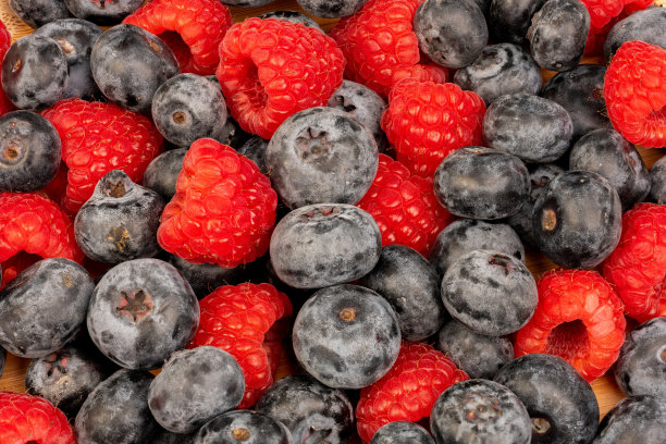 高分辨率的水果照片，展示了樱桃、覆盆子和蓝莓，采用了分焦技术拍摄。图片下载