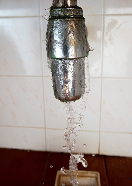 水管下方漏水，排水堵塞。由于水槽排水缓慢，水在管道周围漏出并溅到家中，高速快门冻结运动照片。图片下载