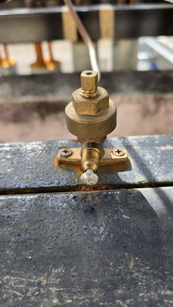 空调系统中使用的黄铜阀门组件特写，安装在金属表面上。这张细致的照片突出了暖通空调安装设置的一部分。图片下载