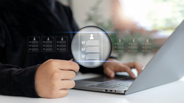 商务人力资源人员使用笔记本电脑分析数字简历，配有放大镜图标，在线招聘、候选人筛选和招聘流程的概念。图片下载