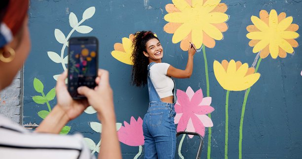 壁画、墙壁和女性的图片，户外和手机屏幕上的艺术、花卉和装饰用于绘画。摄影、画家和创意用于社区项目、社交媒体和使用移动应用的人们。图片下载